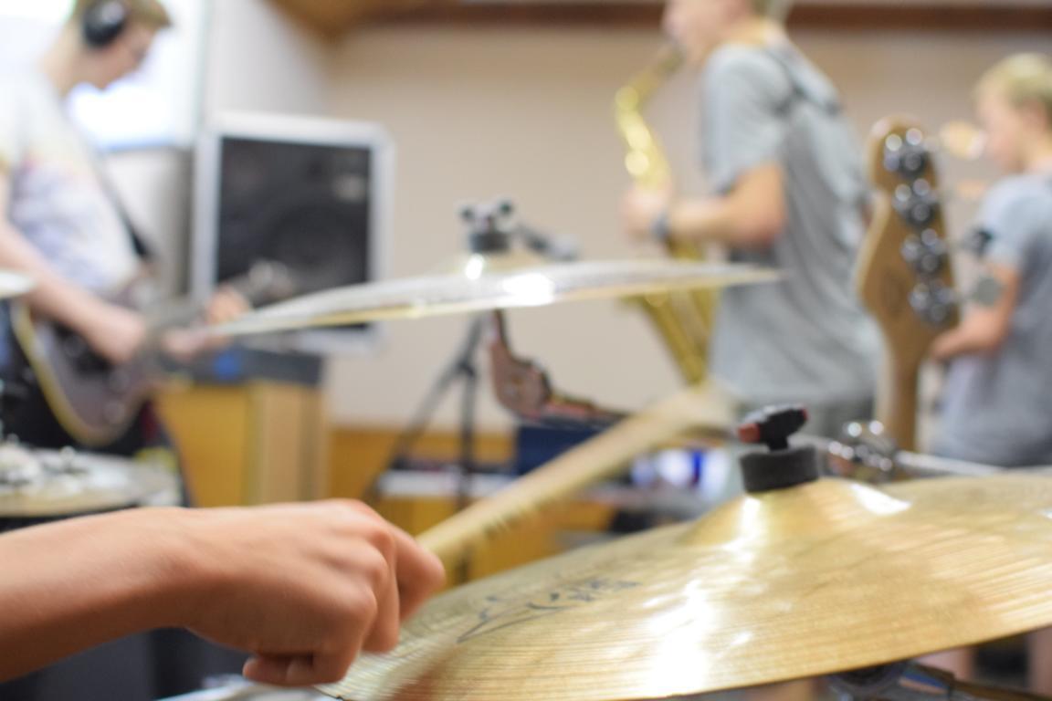 Jugendliche die Musik machen mit Schlagzeug und anderen Instrumenten