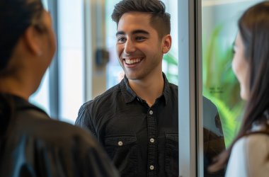 Drei Personen im Gespräch: Zwei Personen stehen mit dem Rücken zur Kamera, ein Mann in der Mitte ist frontal zu sehen und im Fokus.(KI-generiert)