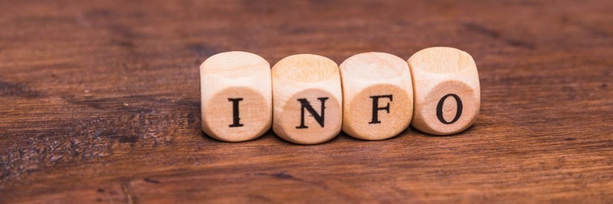 Vier Würfel liegen auf dem Tisch und zeigen zusammengesetzt das Wort INFO.