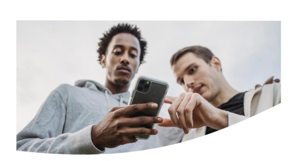 Zwei Männer blicken auf ein Smartphone, einer zeigt mit dem Finger darauf