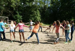 Jugendliche im Kreis die sich an den Händen fassen