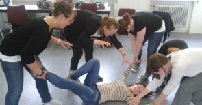 Jugendliche spielen eine Theaterszene, eine Person liegt am Boden 