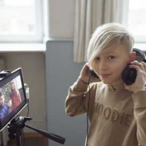 Junge mit Kopfhörern vor einem Tablet