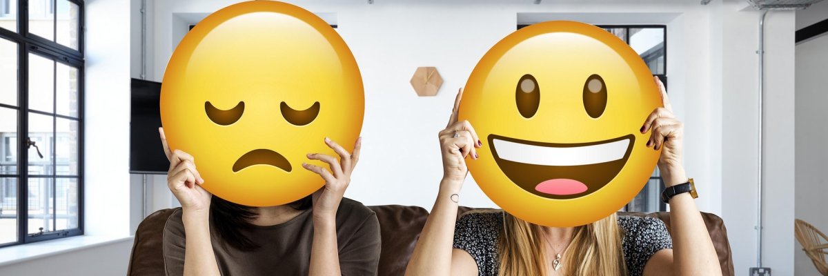 Foto Therapie Foto: Zwei Jugendliche sitzen auf einem Sofa. Vor ihren Gesichtern ist ein lachender bzw. ein trauriger Smiley.