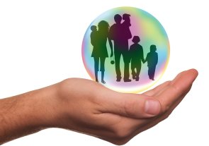 Foto: Ausgestreckte, geöffnete Hand mit einer durchsichtigen Seifenblase, in der die Umrisse einer Familie zu sehen sind.