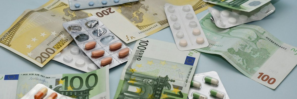 Foto: Geldscheine und Tablettenblister.