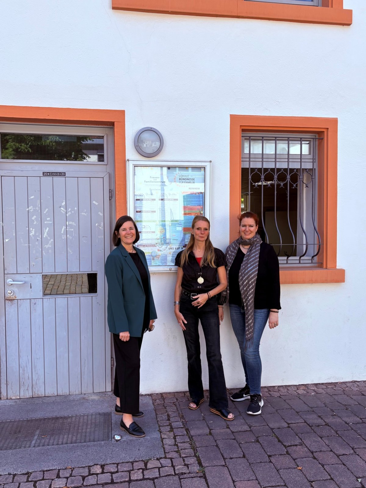 (v.l.n.r.): Sozial- und Jugenddezernentin Christel Sprößler mit Nadine Leber-Christ und Anna Katharina Wenning von den FrauenFreiRäumen in Reinheim vor dem Eingang der FrauenFreiRäume im Hofgut in Reinheim
