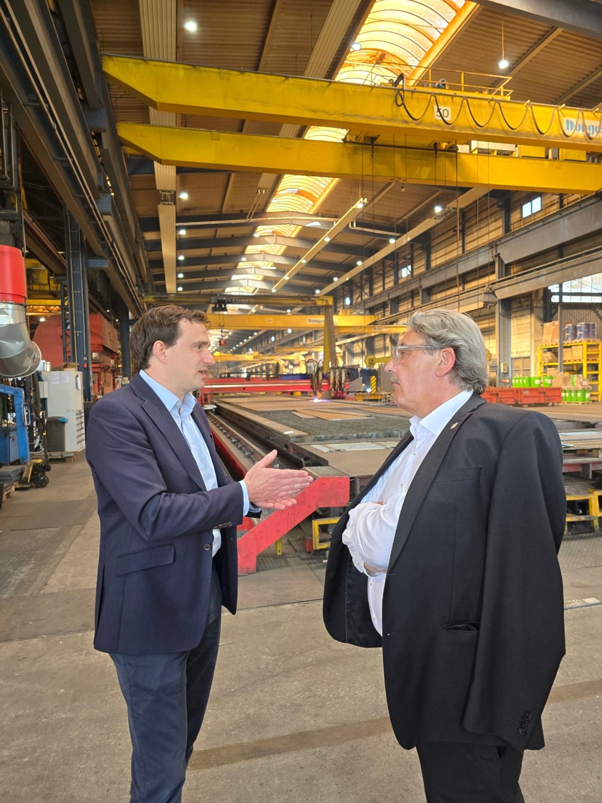 Donges Landrat Klaus Peter Schellhaas im Gespräch mit Dr. Aaron von der Heyden von Donges Steeltec in einer der Produktionshallen.